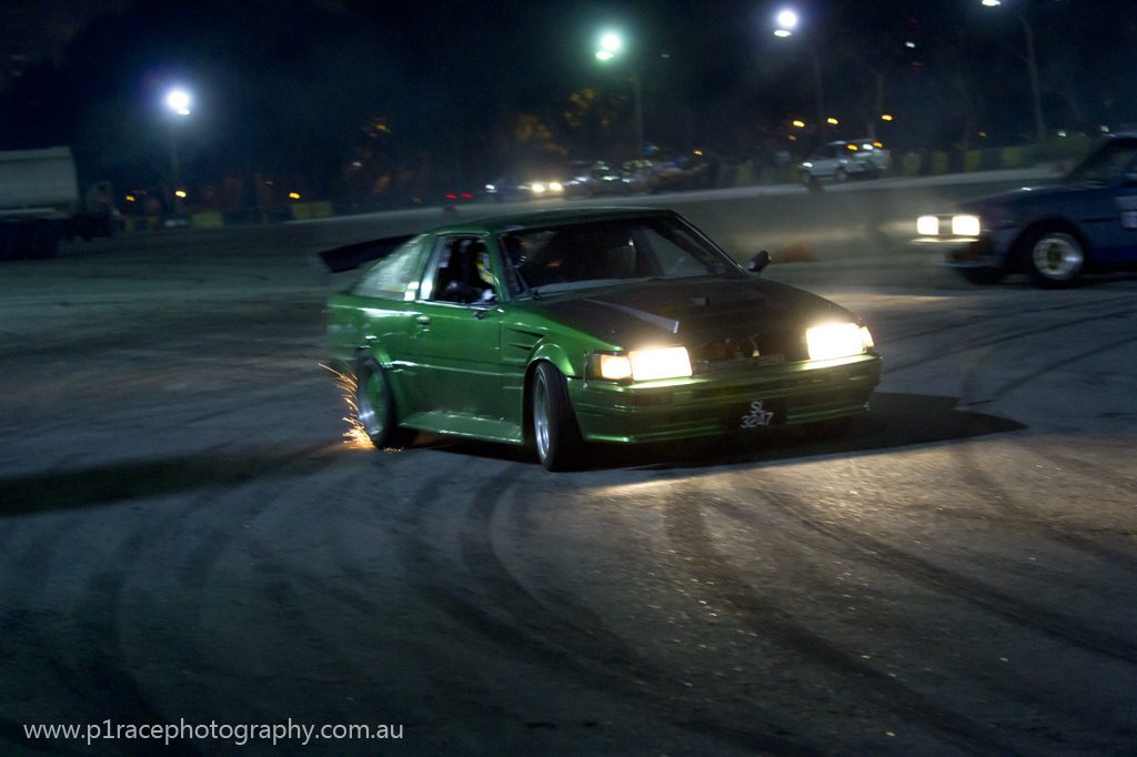 Speed City drift night - Green AE86 Toyota Corolla - front three-quarter drift pan - sparks 2