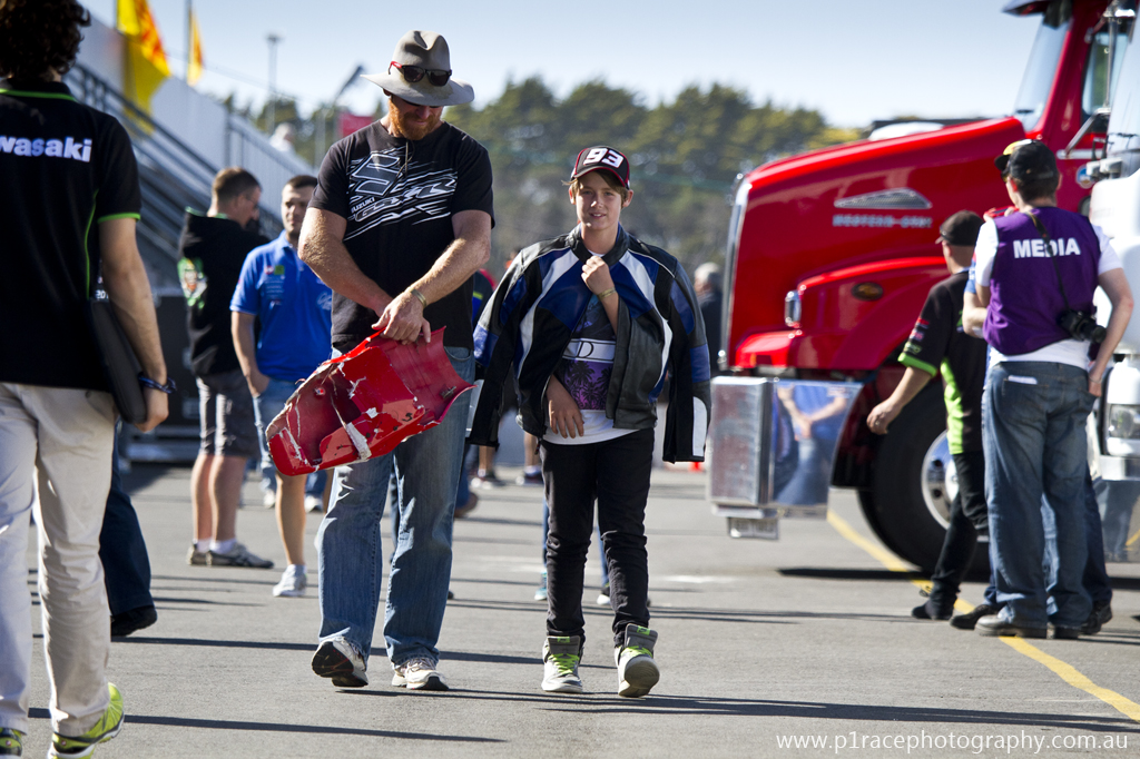 WSBK 2014 - Round 1 - Phillip Island - Sunday - Post-event - Pits - Boy and father walking - holding onto damaged rear fairing 2