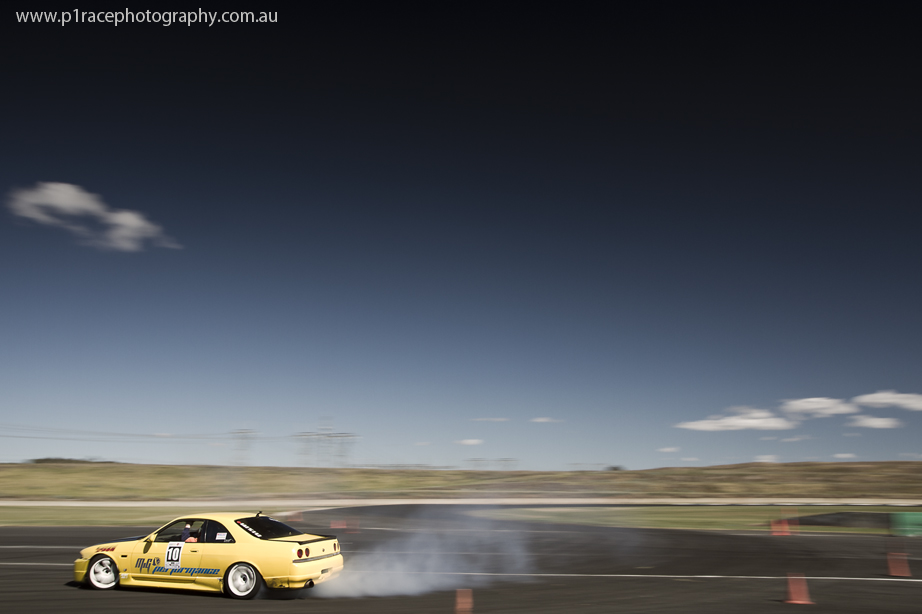 VicDrift 2014 - Round 5 - Manuel Garginian - Yellow R33 Nissan Skyline - Turn 2 exit - Rear three-quarter pan 2